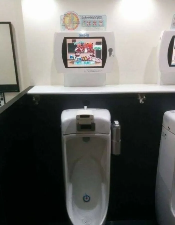 Japanese urinal with an interactive screen displaying a video game, showcasing unique technology.
