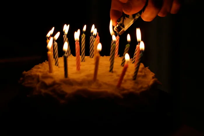Lighting birthday candles on cake in dark room, illustrating people sharing conspiracy theories they believe in