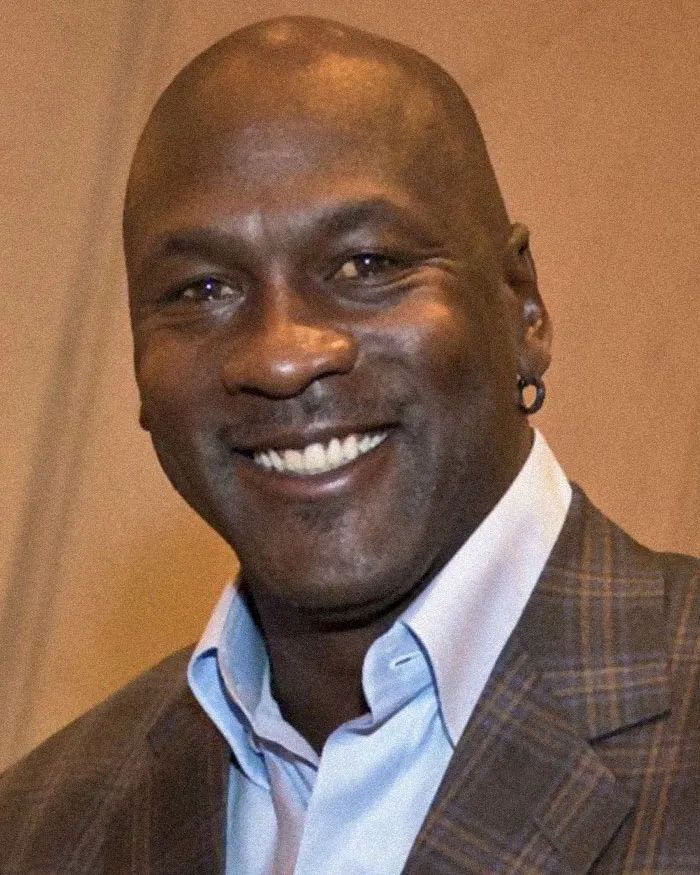 Smiling man in a checkered blazer and light blue shirt, representing people sharing conspiracy theories they believe in.