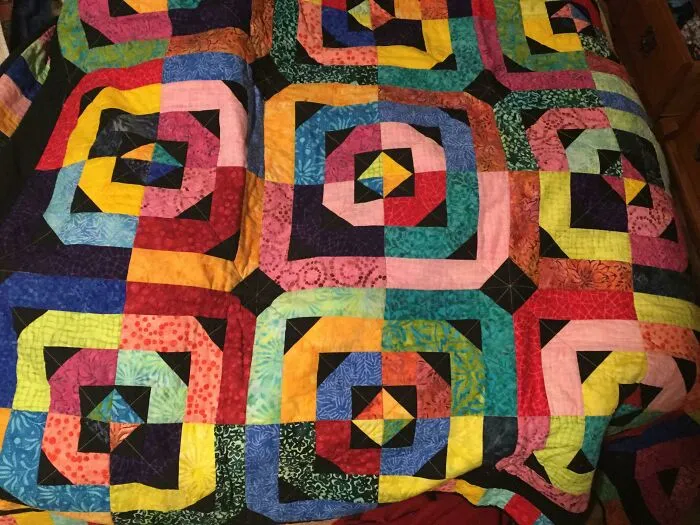 Mi abuela me hizo esta colcha para mi graduación. Pensó que los arcos iris serían buenos porque soy gay. Mis abuelos son nuevos en esto de los gays, pero hacen lo que pueden