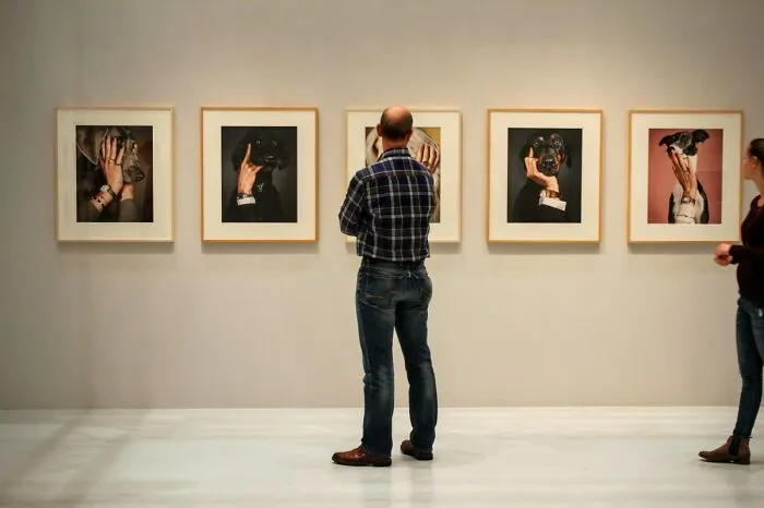 Two people observing framed dog portraits in a gallery, illustrating weird laws from around the world.