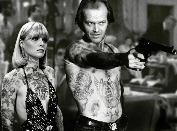 Famous people photoshopped with tattoos, altering perception, in a dramatic black and white scene.