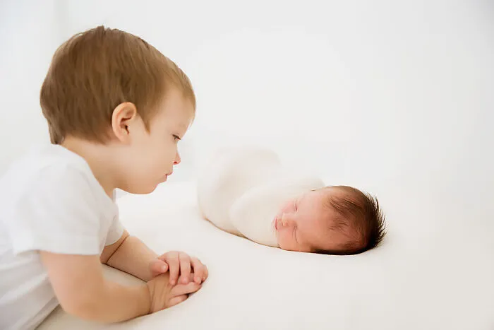 2 Year Old Little Brother Looking At His Little Sister