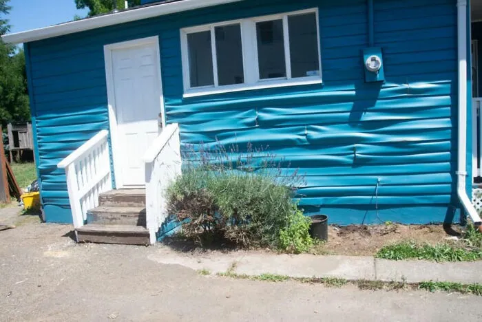 Así de caliente está en Portland ahora mismo, esta es la casa de mi vecino y el revestimiento de vinilo de su casa se está ampollando bajo el sol con 42 grados de calor