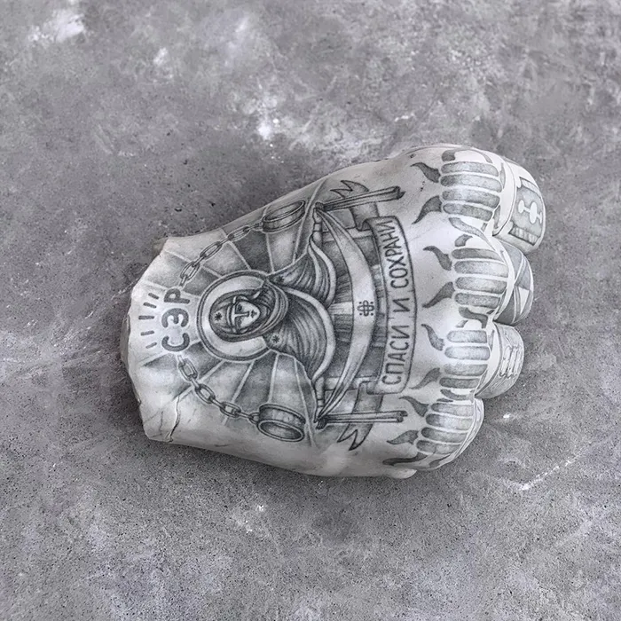 Tattooed sculpture by Italian artist featuring intricate designs on a clenched fist, showcasing unique artistic expression.