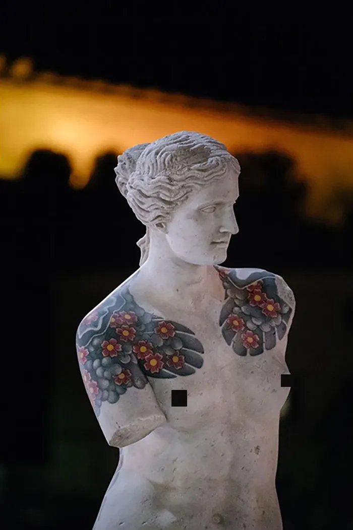 Sculpture with vibrant tattoos on shoulders and chest by Italian artist, showcasing tattoos beyond human skin.