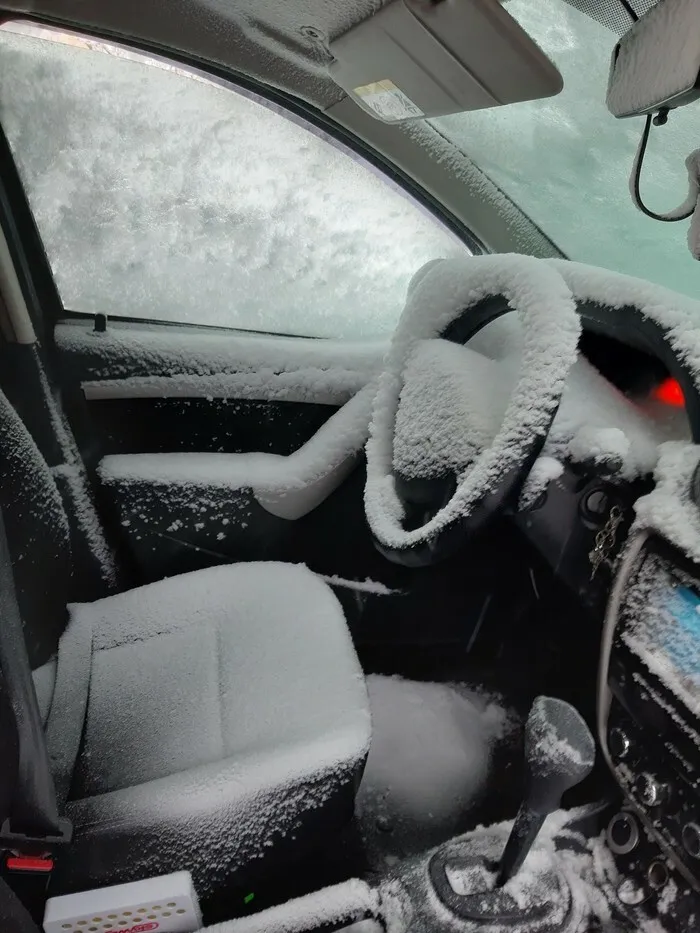 Car interior completely covered in snow and ice, showing nature's impact making people go well that sucks.