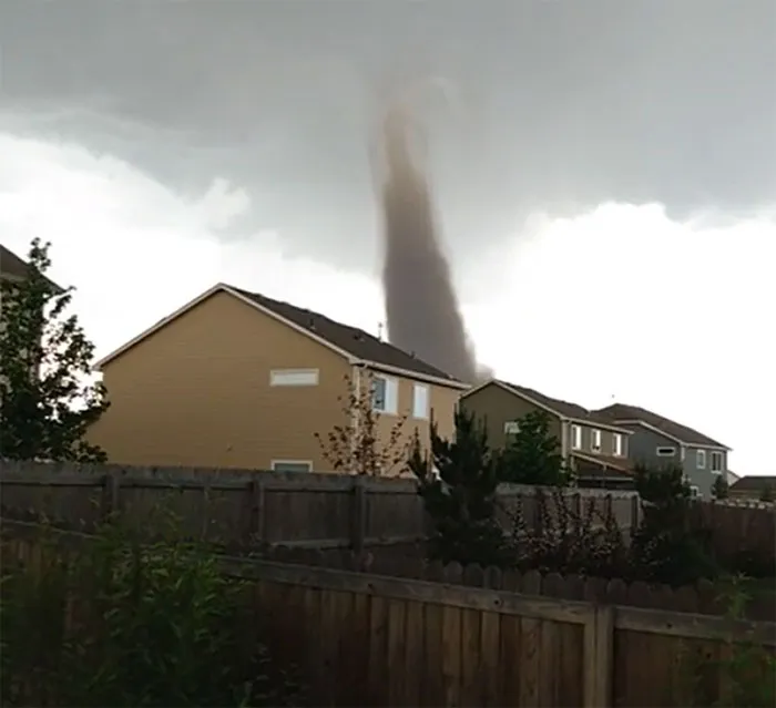 Tornado touching down near suburban houses, showcasing nature moments that make people go well that sucks.