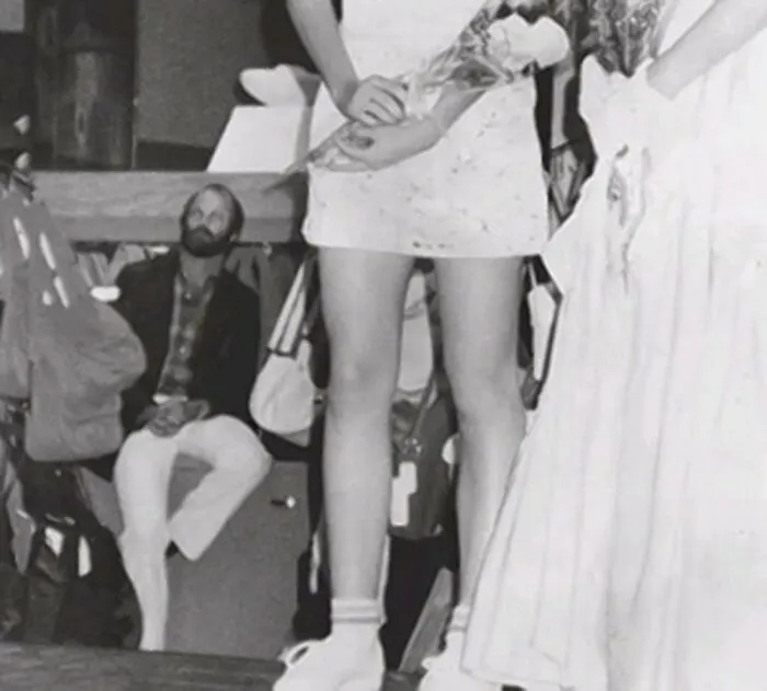 Foto del asesino en serie Christopher Wilder acechando en el fondo durante un desfile de la revista Seventeen en el centro comercial Meadows en Las Vegas el 1 de abril de 1984