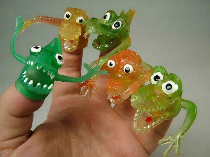 Vintage finger puppet toys from the '70s, colorful creatures with wide eyes and playful expressions.