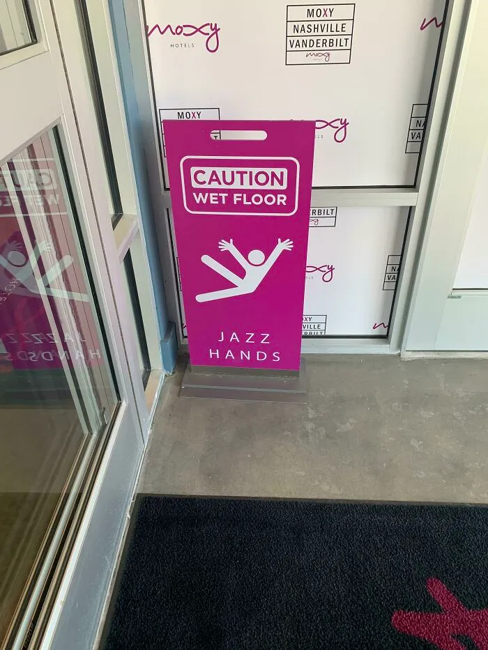 Funny sign in a hotel hallway: "Caution Wet Floor" with an icon doing jazz hands.