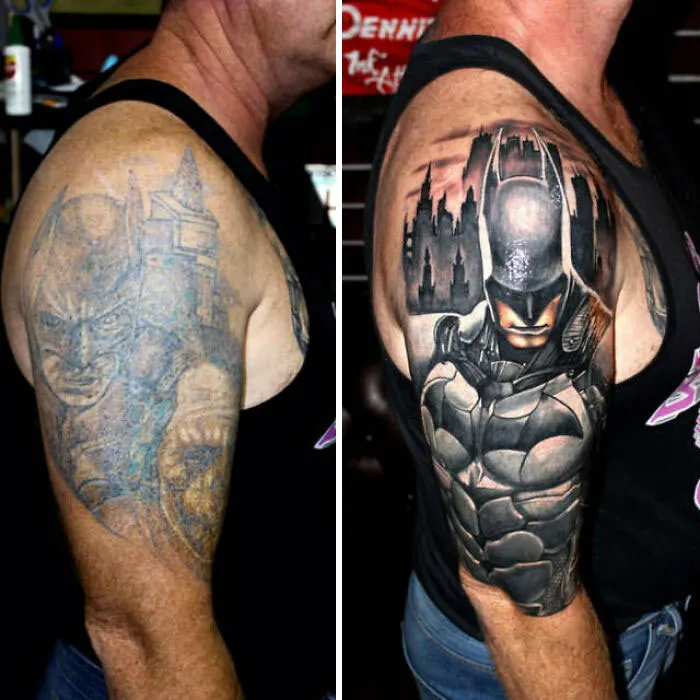 Tattoo cover-up transforming faded Batman design into a detailed, vibrant cityscape superhero on a man's upper arm.