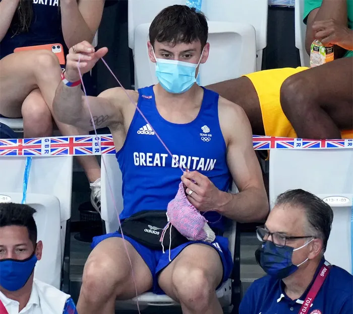 El medallista de oro olímpico Tom Daley tejiendo en las gradas para calmar sus nervios mientras ve los saltos de trampolín
