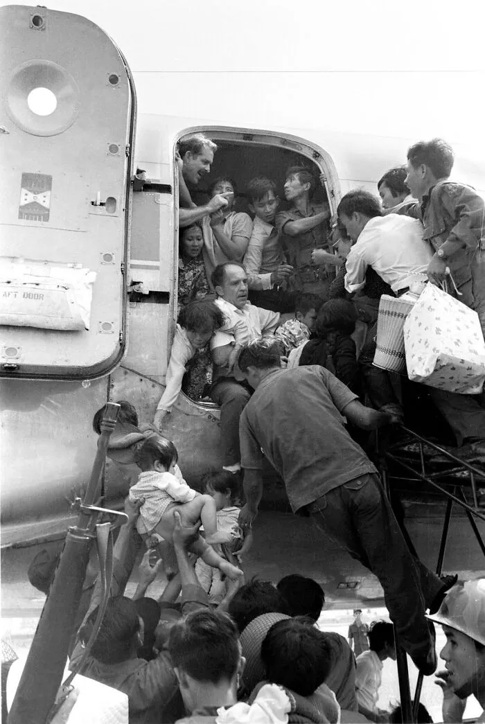 Evacuation scene with people boarding an aircraft, capturing an important historical moment of urgency and hope.