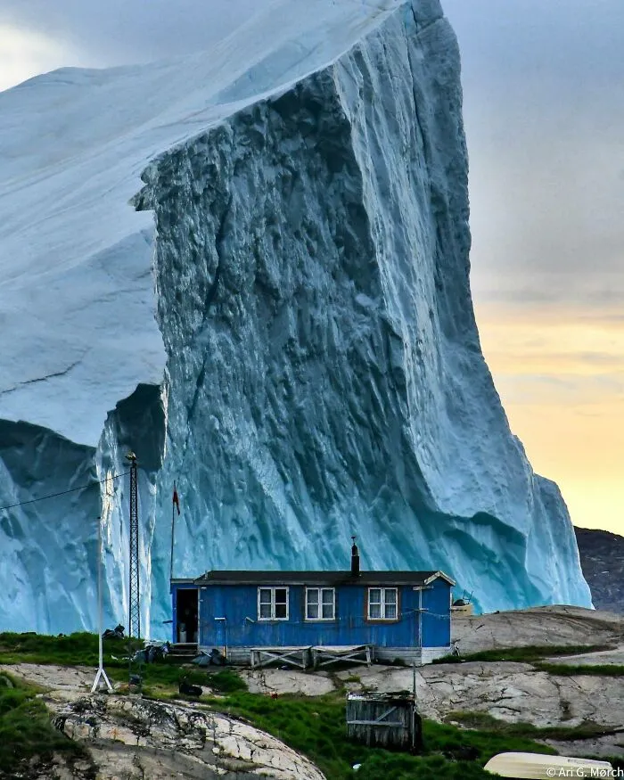 Un iceberg pasa junto a una casa en Groenlandia