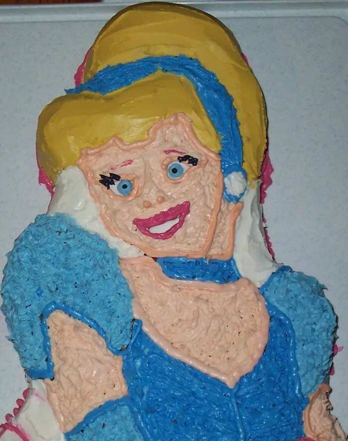 Funny cake fail resembling a character with uneven icing and bright colors.