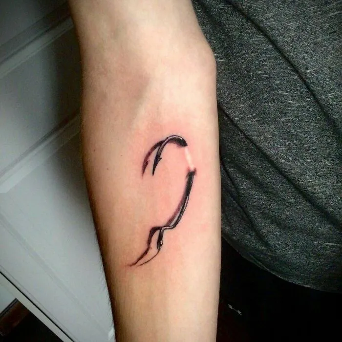 Tattoo covers scar on forearm, transforming it into a unique design.