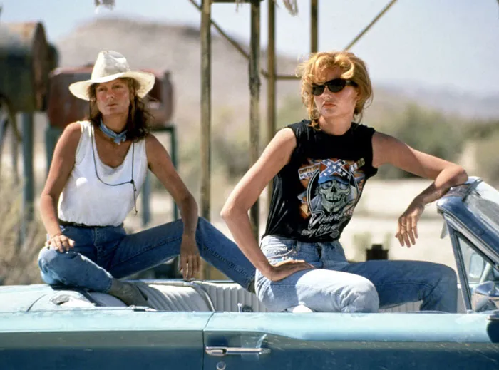Thelma and Louise sitting on a cabriolet