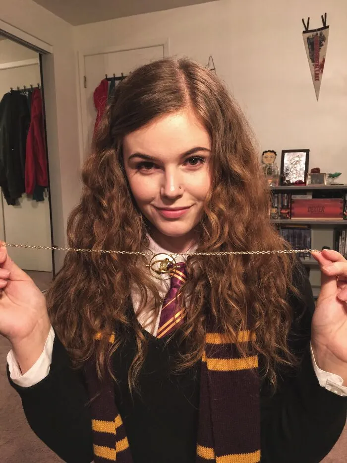 Young woman in a simple Harry Potter costume holding a Golden Snitch necklace, showcasing easy Halloween costume ideas.