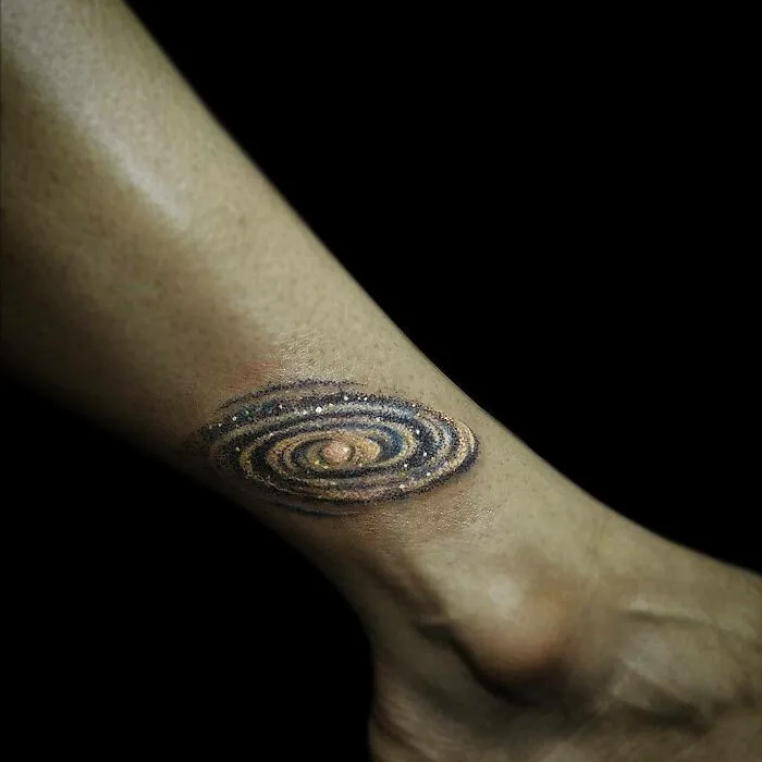 Galaxy tattoo on an ankle, showcasing an interesting first tattoo idea.