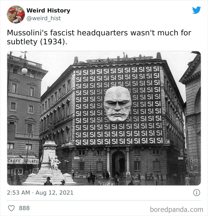 Black and white photo of Mussolini's fascist headquarters in 1934 with a large head sculpture and repeated "SI" banners.