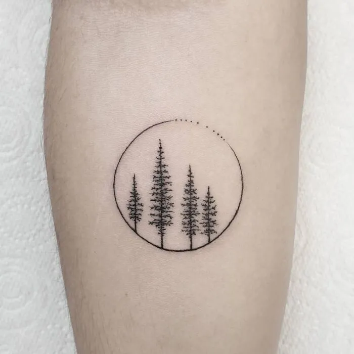 Minimalist tree tattoo design in a circle, showcasing a first tattoo idea on the forearm.