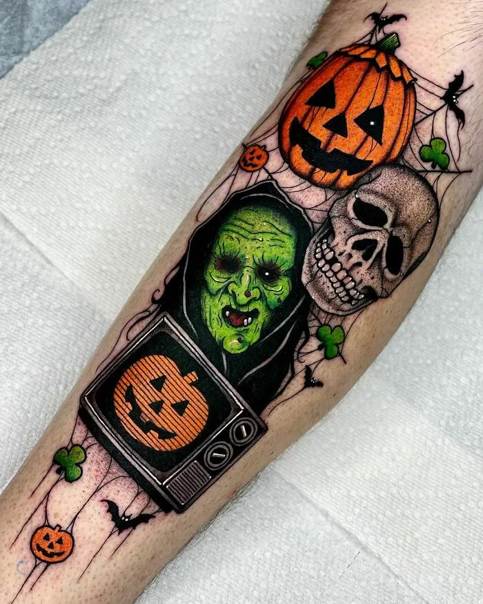 Spooky Halloween tattoo featuring a green witch, a skull, and jack-o'-lanterns with a vintage TV on an arm.