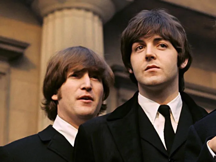 Young John Lennon and Paul McCartney next to each other