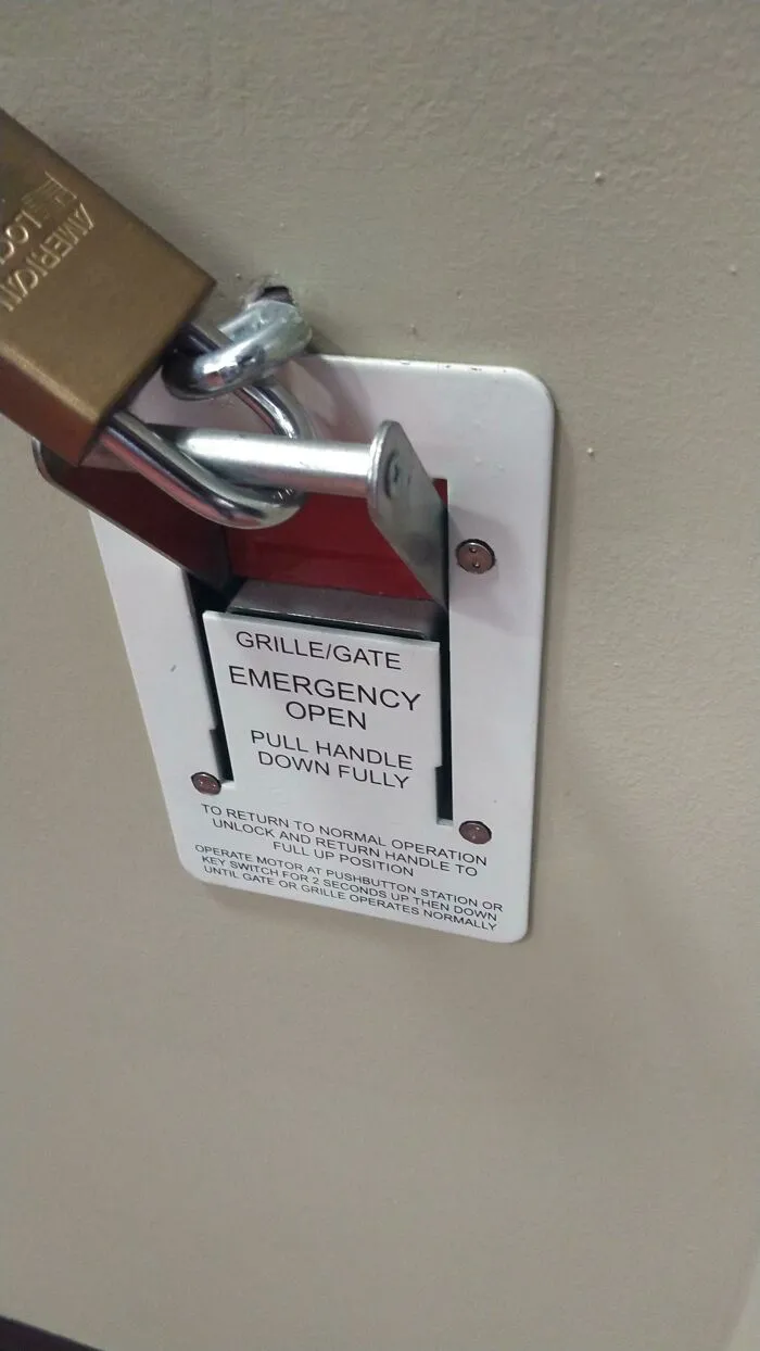 Mi universidad local puso intencionalmente un gancho en la pared para poner un candado a un interruptor de emergencia
