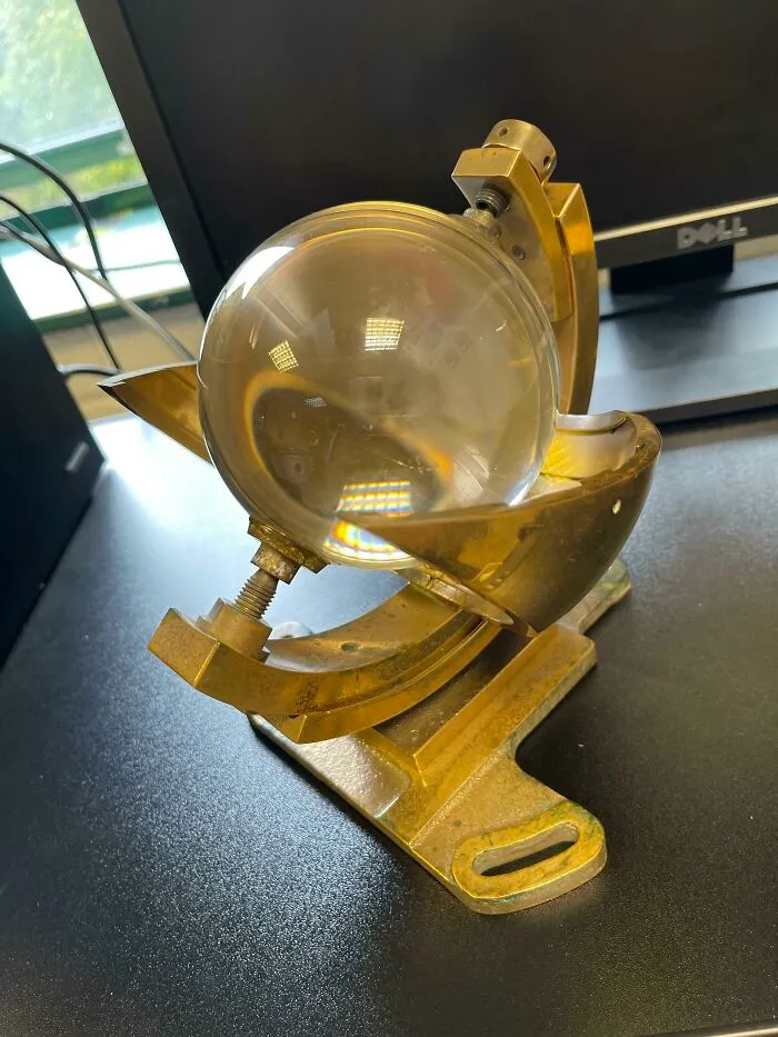 Weird Glass Ball, Suspended By Screws, In A Metal Frame, Bronze Or Gold Colour In Appearance
