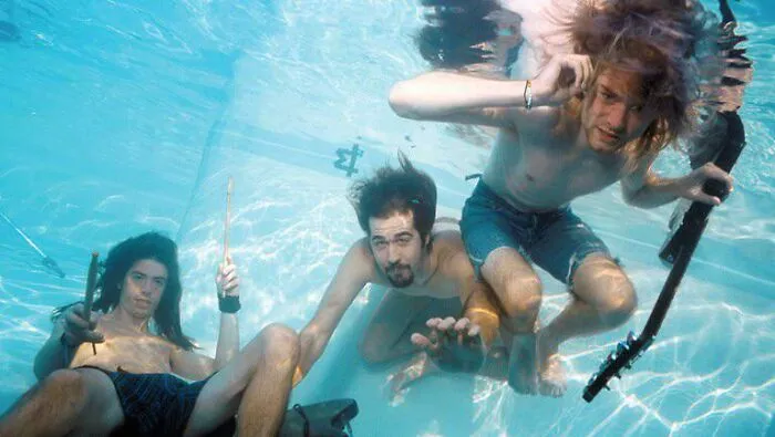 Historical photo of three men underwater, holding musical instruments, showcasing a unique perspective.