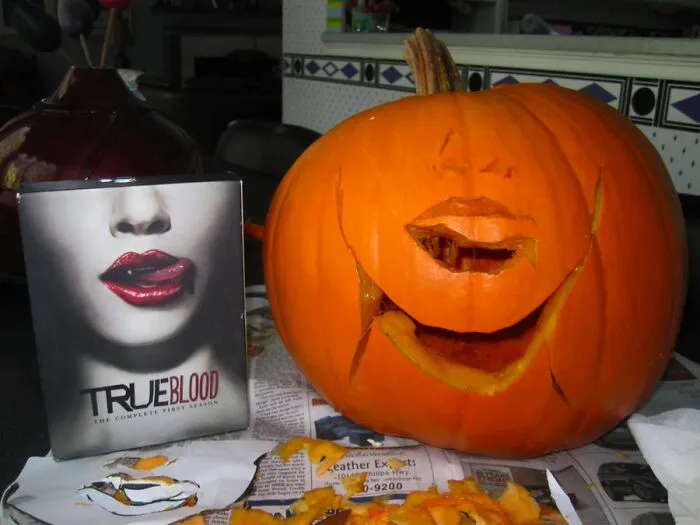 A poorly carved pumpkin attempt next to a True Blood DVD case, representing funny Halloween fails.