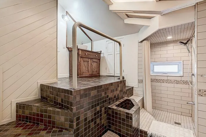Unusual bathroom design with elevated tiled platform and awkward layout, showcasing poor interior in homes.