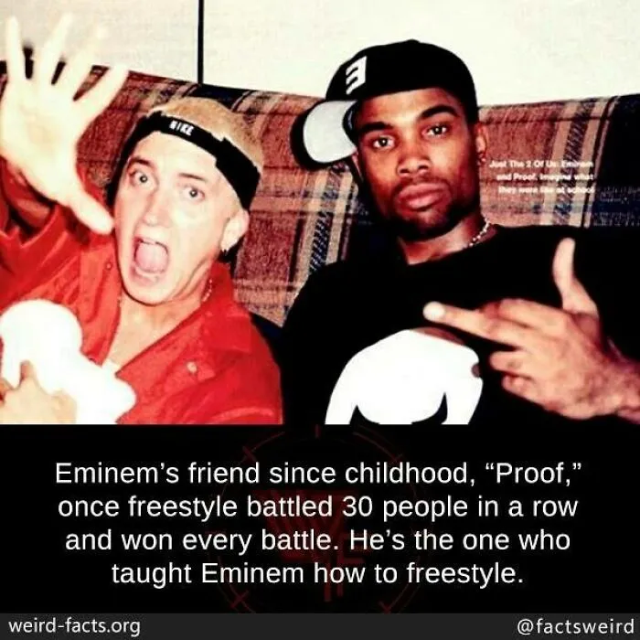 Two men sitting on a couch, one making a hand gesture, illustrating weird facts about the world and freestyle battle history.