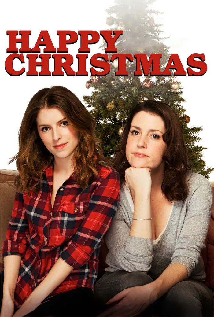Two women sitting in front of a Christmas tree, embodying Christmas movie theme.