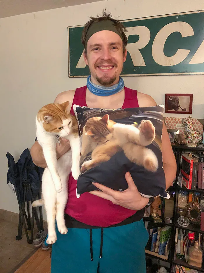Mi marido posando con el cojín que le hice de nuestro gato para Navidad