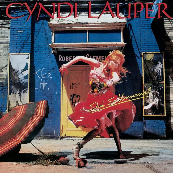 Colorful album cover featuring a woman dancing in a vibrant urban scene, representing one of the greatest album covers.