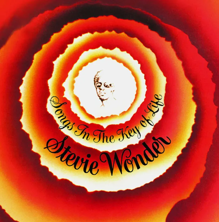 Iconic album cover with vibrant concentric rings and artist's sketch, highlighting greatest album design.