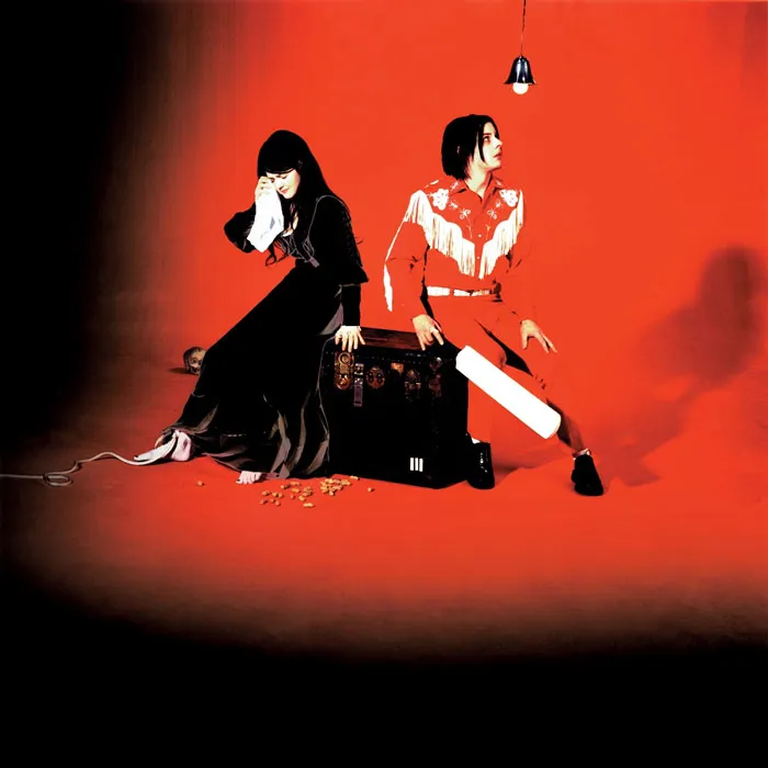 Two figures in a striking red and black album cover setting.