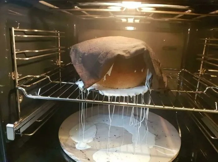 Cuando pones el horno demasiado alto mientras dejas subir la masa de la pizza. Sí, eso es un tazón derretido, masa horneada y un paño de cocina quemado