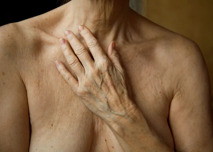 Manos en el pecho, de la serie “Growing Old” de Marna Clarke