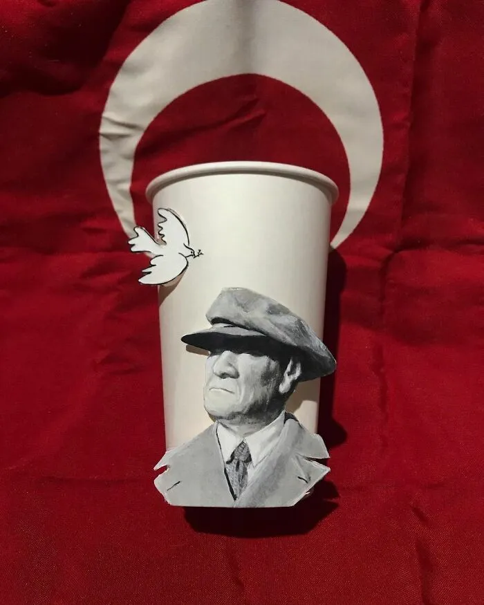 Paper cup illustration featuring a detailed grayscale portrait and a white dove, showcasing creative art on paper cups.