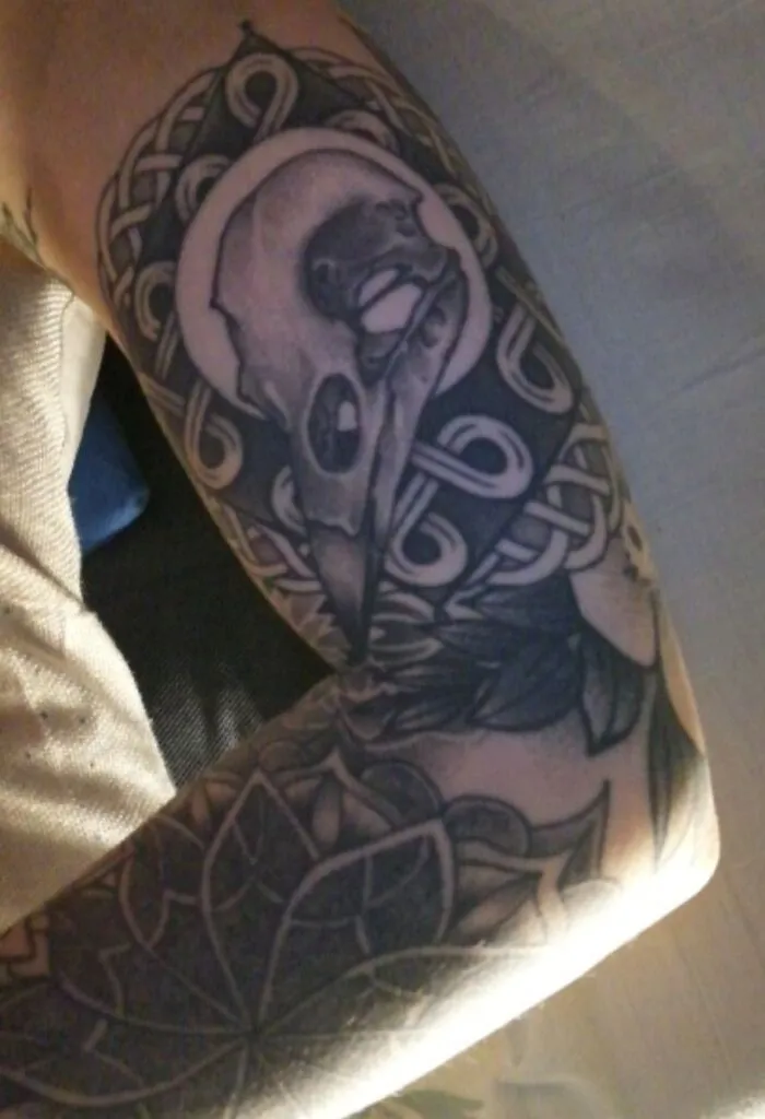 Skull and intricate pattern tattoo on arm showcasing impressive new tattoo art.