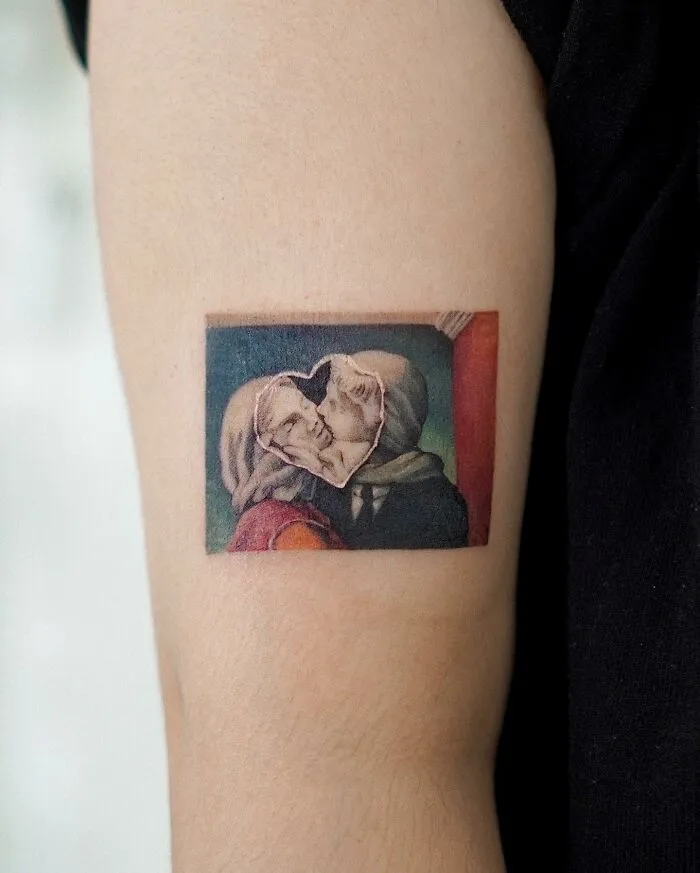 Tattoo of two figures kissing, resembling a painting on an upper arm.