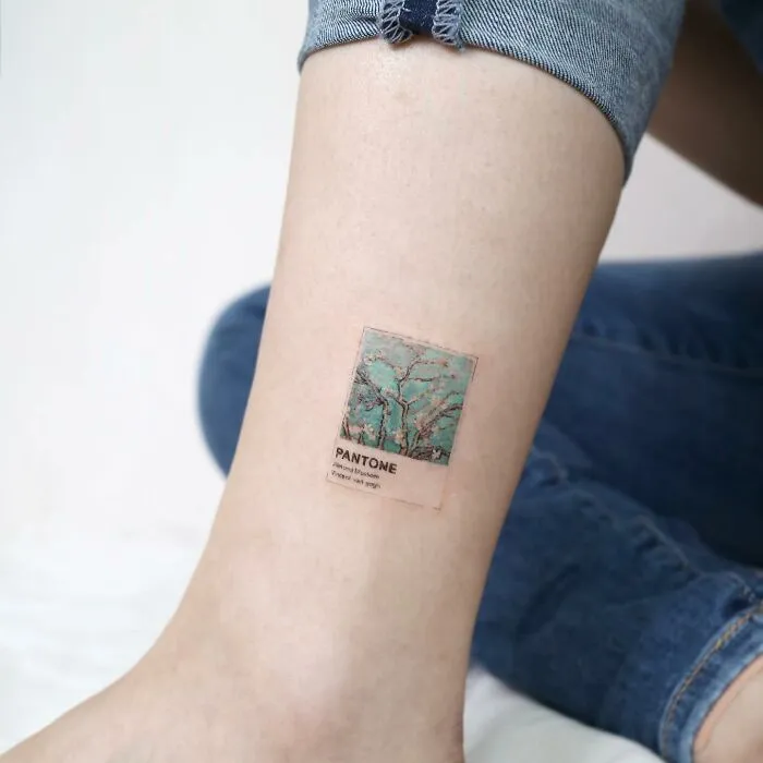 Painting-like tattoo resembling a Pantone color swatch on a person's leg, showcasing intricate design.