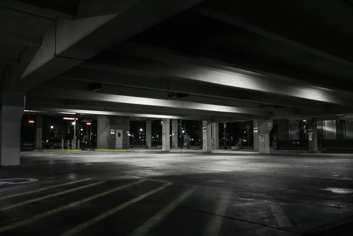 Empty dimly lit parking garage at night illustrating basic and genius safety tips everyone should know in public spaces.