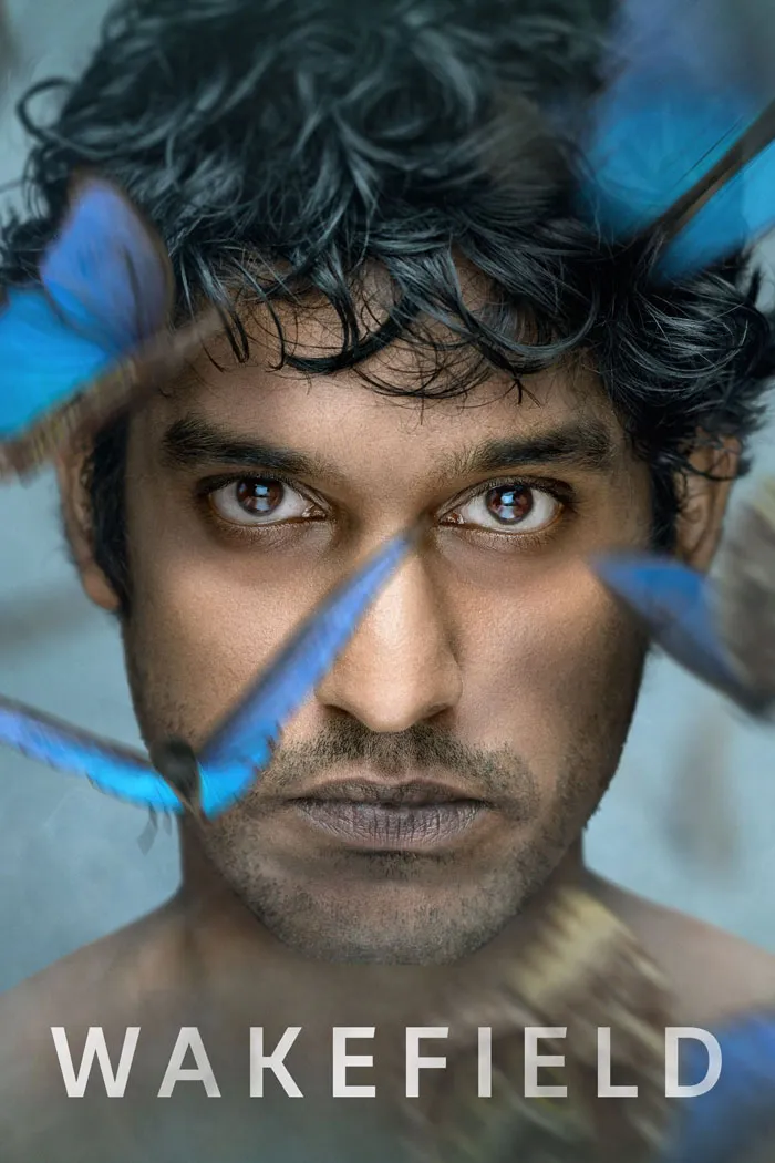 "Close-up of a man with blue butterflies, representing a medical worker theme from TV show 'Wakefield'."