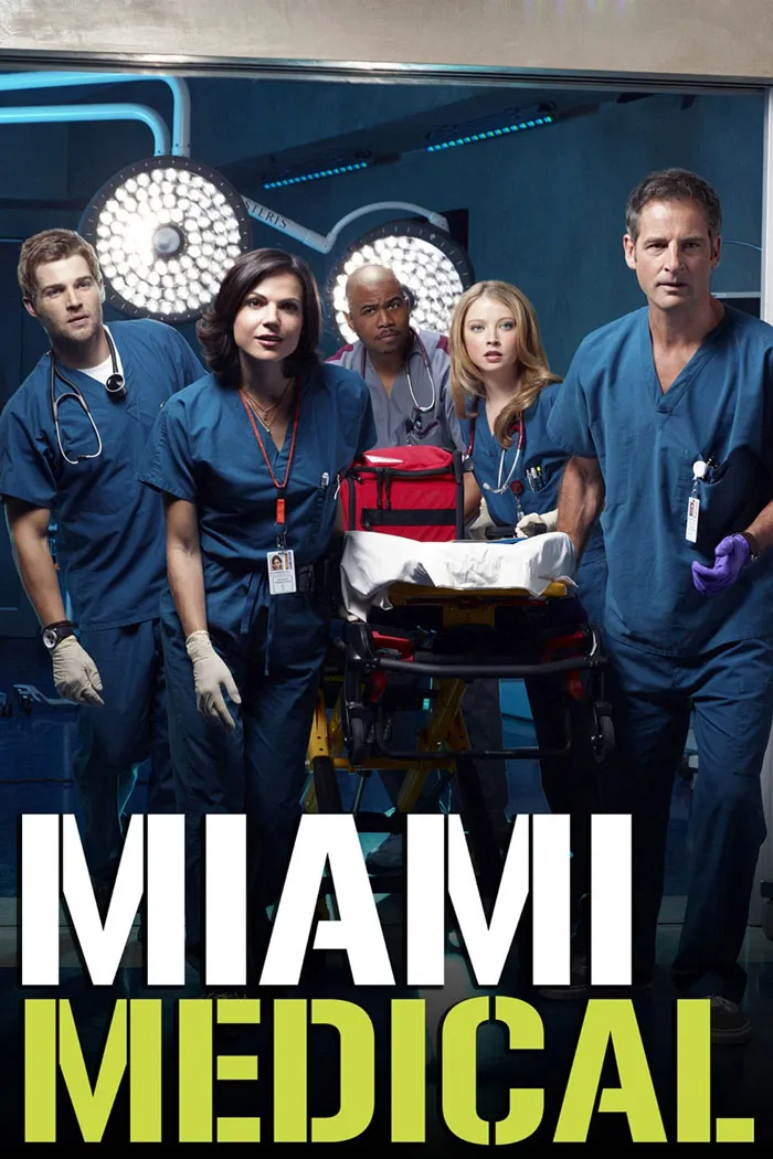 TV show featuring doctors in scrubs around a stretcher in an operating room.