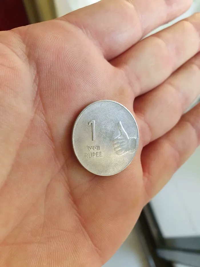 La moneda de 1 rupia de la India tiene solo un tipo dando un pulgar hacia arriba en ella