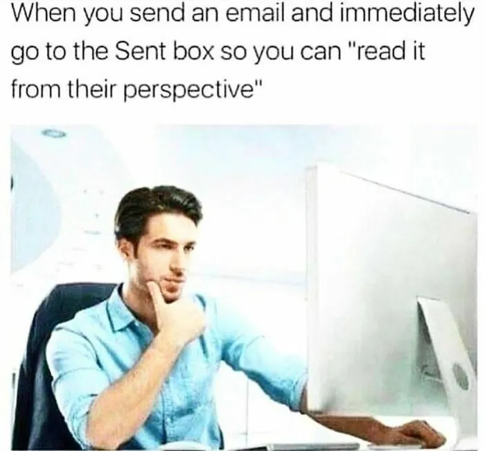 Man at desk looking at computer screen, hand on chin, depicting corporate humor about email perspective.